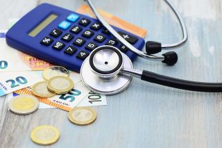Foto: Stethoskop, Bargeld und Taschenrechner